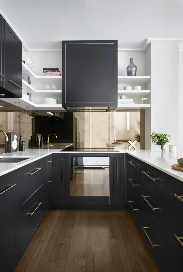 Smarter Bathrooms and Kitchens - a modern kitchen design with wooden floor, white marble kitchen bench-top, and an elegant mix of black and gold. Beautiful kitchen designs built by kitchen renovation Melbourne specialist