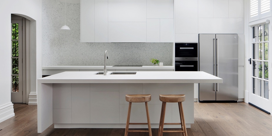 Smarter Bathrooms and Kitchens - a modern kitchen with open plan living, ivory white furnitures, and wooden floor. Beautiful kitchen designs built by kitchen renovation Melbourne specialist