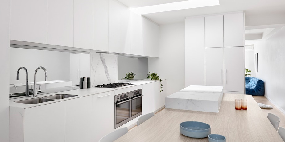 Smarter Bathrooms and Kitchens - a modern kitchen with white marbles and wooden dining. Beautiful kitchen design built by kitchen renovations Melbourne specialist