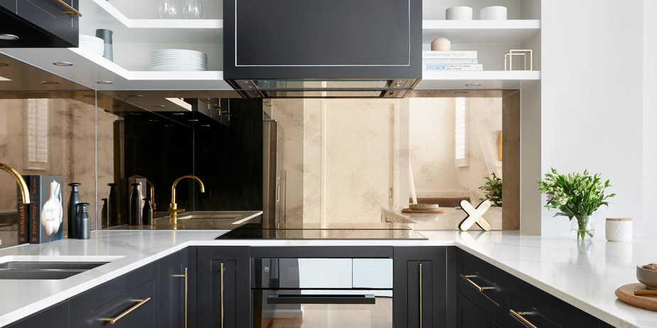 Smarter Bathrooms and Kitchens - a modern kitchen with a stunning combination of dark grey and gold kitchen vanities, white marble top, and kitchen mirror. Beautiful kitchen designs built by kitchen renovations Melbourne specialist