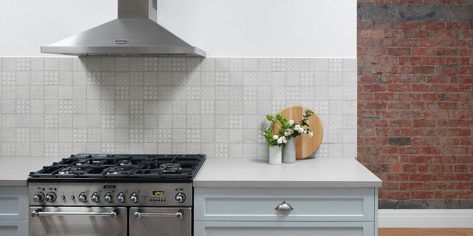 Smarter Bathrooms and Kitchens - a modern kitchen design with wooden floor, kitchen cabinet in the middle with wooden top, beautiful kitchen wall tiles, and unique open brick layer on some parts of the kitchen wall. Beautiful kitchen designs built by kitchen renovation Melbourne specialist