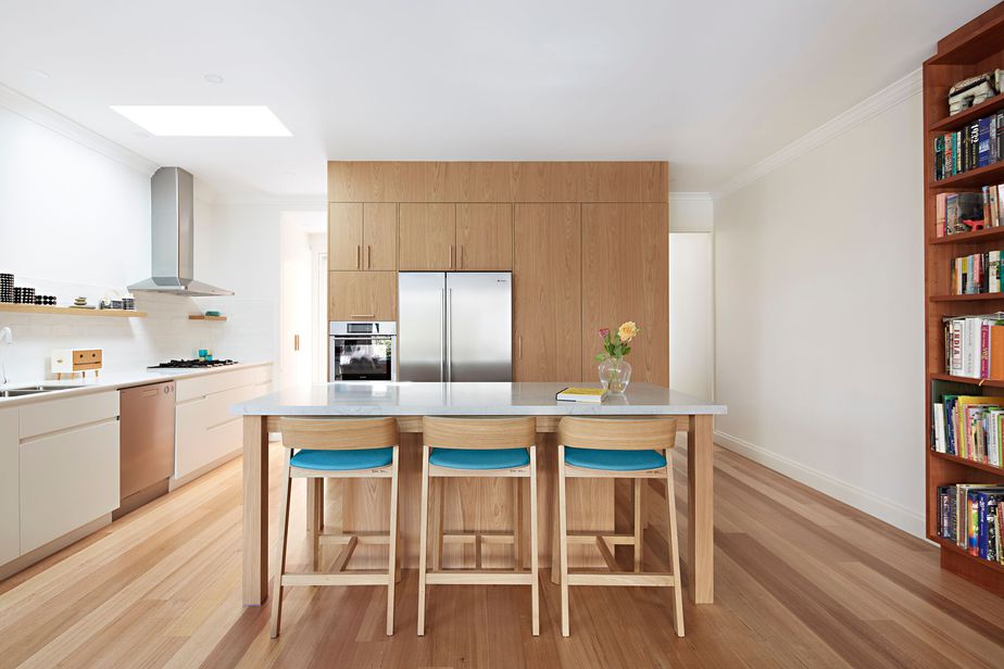 Smarter Bathrooms and Kitchens - a modern kitchen with stunning full wall wooden kitchen cabinets, wooden floor, and marble top dining table. Beautiful kitchen designs built by kitchen renovations specialist Melbourne