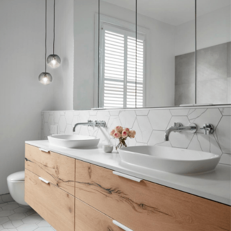 Smarter Bathrooms and Kitchens - an elegant shower, ivory white sink, and beautiful herringbone pattern bathroom wall tiles in a modern bathroom. Beautiful bathroom designs built by bathroom renovations Melbourne specialist