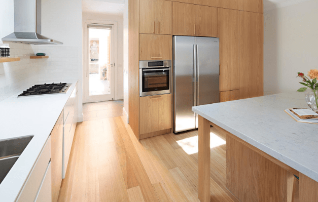 Smarter Bathrooms and Kitchens - a modern kitchen with ivory white furnitures and wooden floor. Beautiful kitchen designs built by kitchen renovation Melbourne specialist